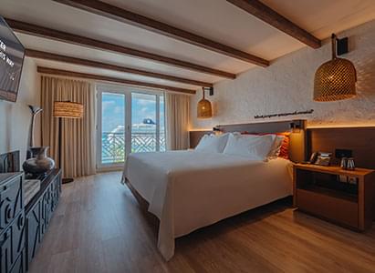 A queen bed in a hotel room in the Aruba resort