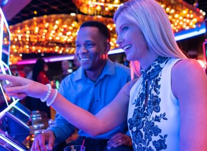 Smiling couple playing casino game machine