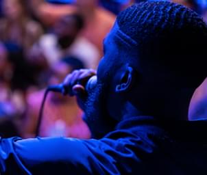 Man with a microphone singing to an audience